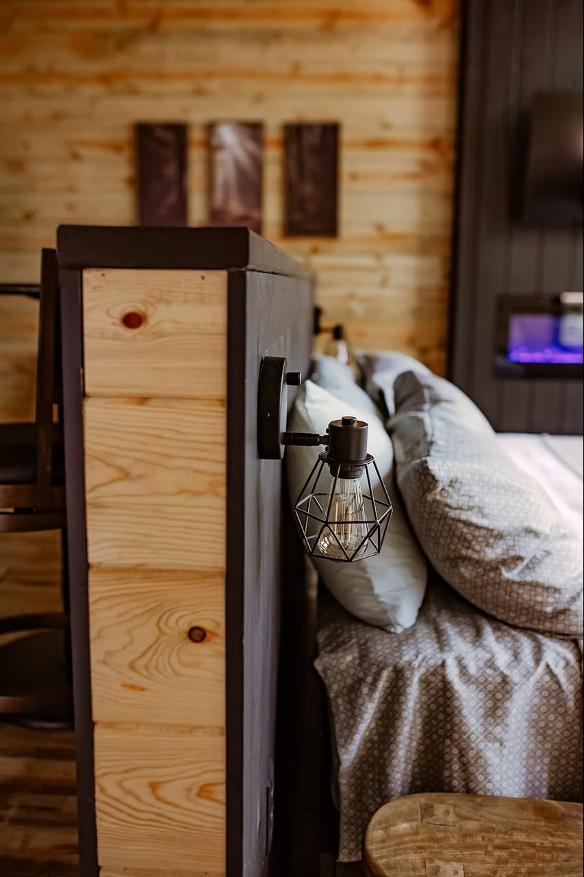 Rustic bedside with geometric cage lamp and cozy textured bedding