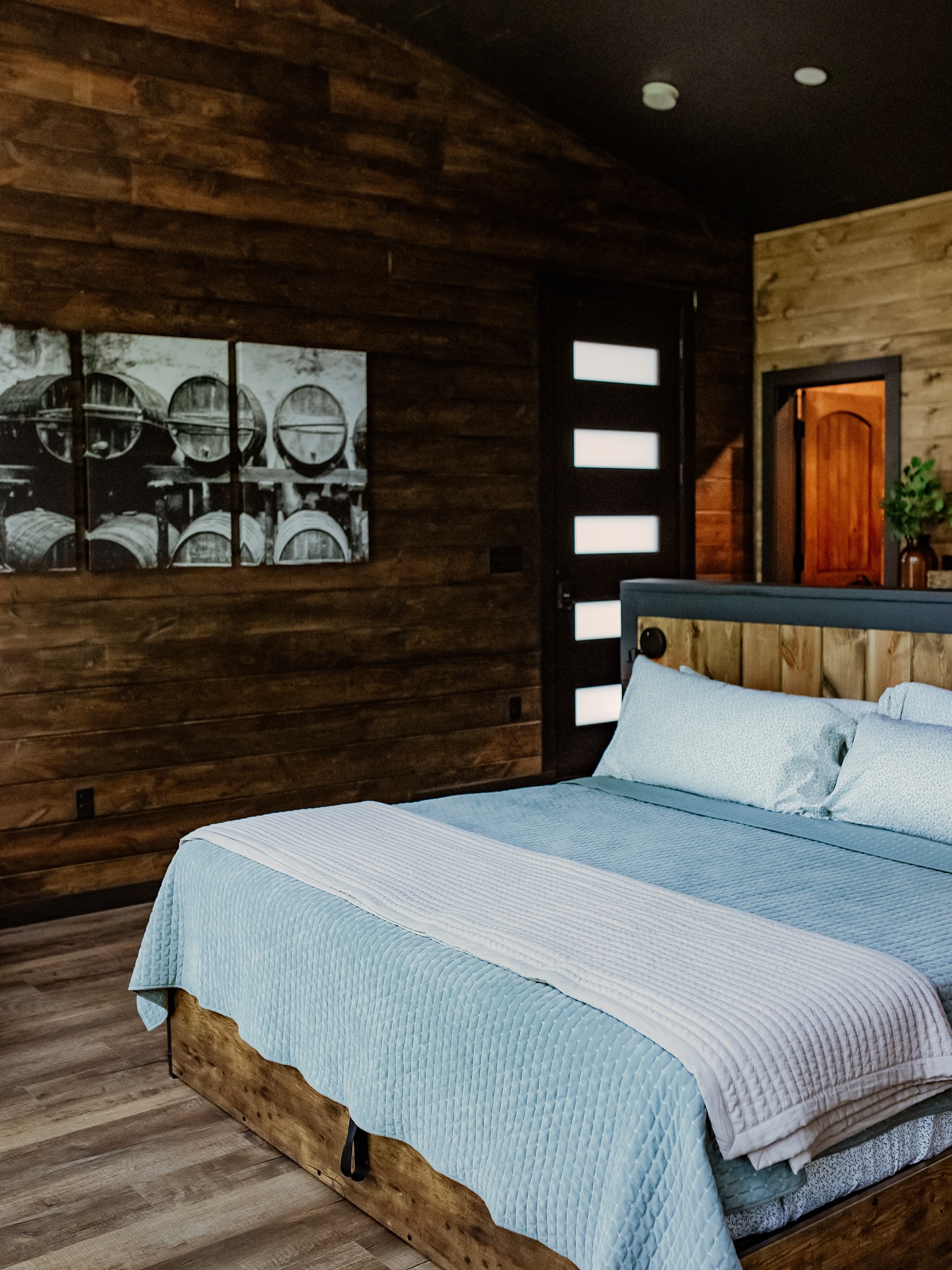 Rustic wooden bedroom with blue bedding and wine barrel art