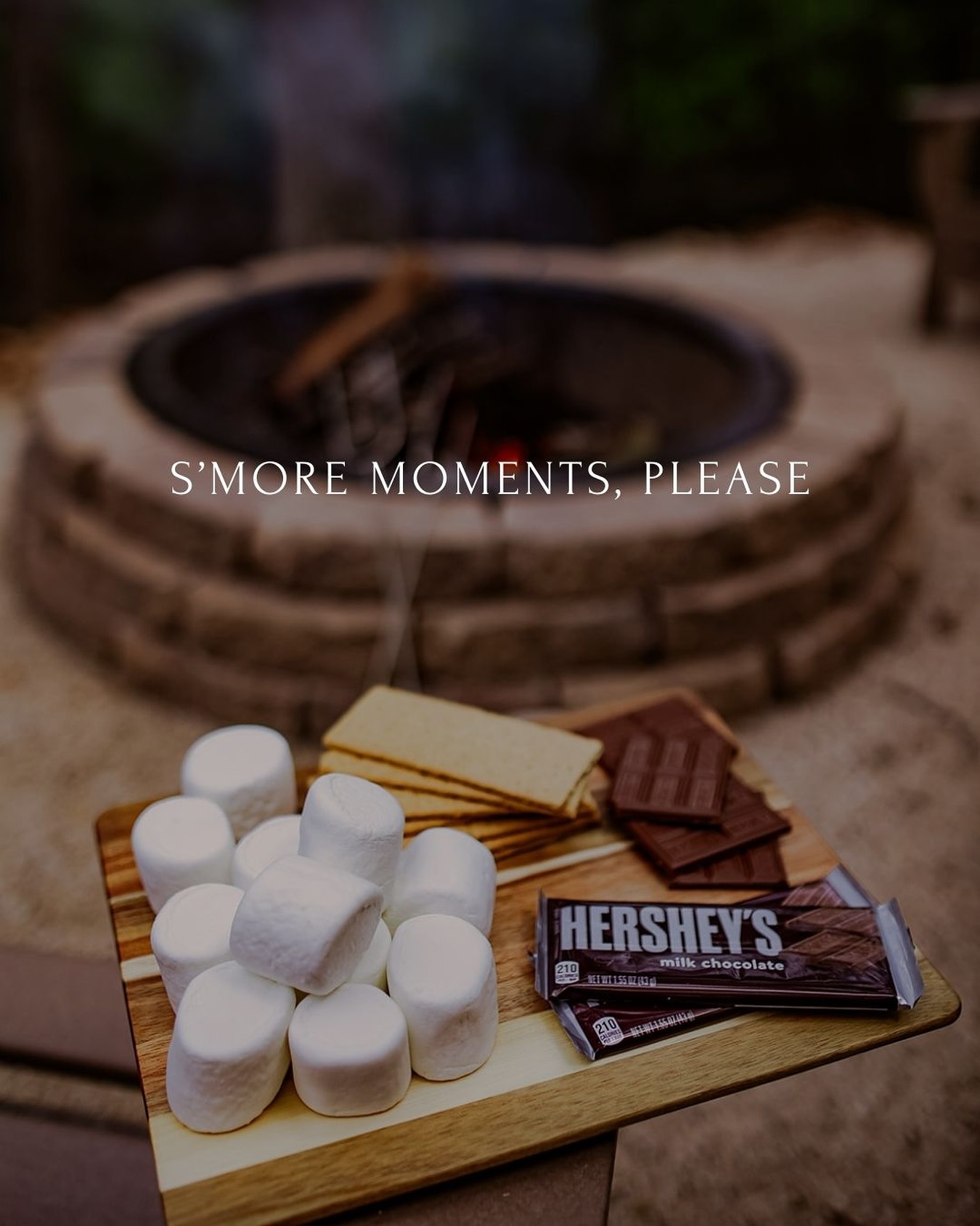 Marshmallows, chocolate, and crackers ready for s'mores by a fire pit